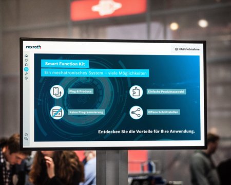 Blick auf einen Monitor auf der Messe. Auf diesem sind Infos zum Smart Funktion Kit von Bosch Rexroth zu lesen. 